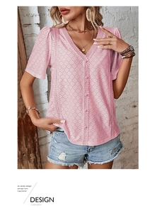 Detail of pink V-neck shirt featuring intricate eyelet embroidery and decorative buttons
