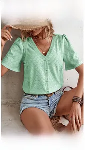 Detail of mint green V-neck blouse featuring intricate geometric broderie anglaise lace