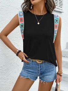 Detail of colorful crochet patchwork on shoulder straps of black sleeveless summer top