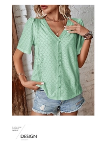 Detailed view of mint green V-neck blouse with intricate eyelet lace embroidery and buttons
