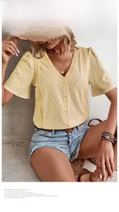 Detailed view of yellow eyelet embroidered V-neck shirt with puff sleeves and buttons