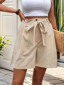 Detail of high waisted summer shorts with adjustable belt and textured linen fabric
