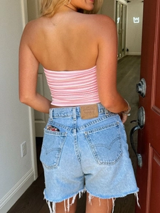 Detail of pink striped tube top paired with high-waisted denim shorts back view