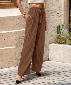 Detail of high waisted brown wide leg pants showing vertical texture and elastic drawstring