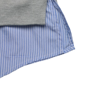 Détail de l'ourlet superposé en tricot gris et extension de chemise à rayures bleues