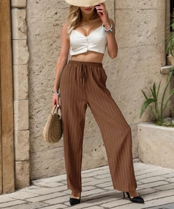 Detailed macro view showing the pleated texture and drawstring waist of brown trousers