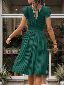 Detail of elegant dark green pleated dress featuring a deep V-back with delicate ties