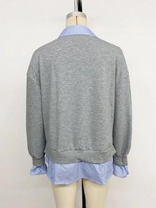 Détail d'un sweat-shirt gris avec col et ourlet de chemise rayée pour femmes
