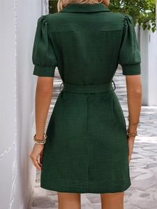 Detailed back view of a dark green textured shirt dress featuring a waist-defining belt