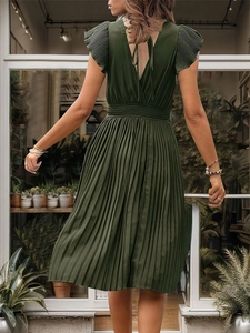 Detail of elegant dark green pleated midi dress with butterfly sleeves and smocked waist