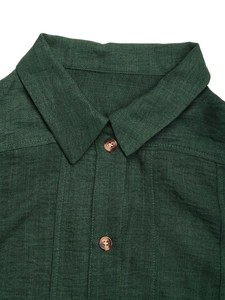 Detailed close-up of dark green textured shirt collar with amber buttons