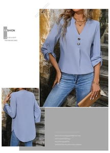 Detail view of light blue V-neck blouse with button accents and pleated neckline design