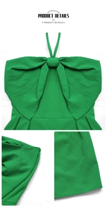 Detail of green halter neck jumpsuit showing crinkled crepe fabric and large bow design