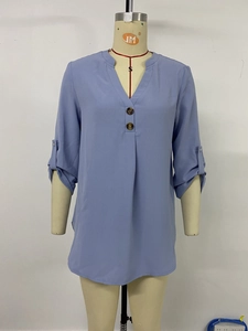 Detail view of v-neck women shirt with decorative buttons and adjustable roll-up sleeves