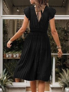 Detail of elegant backless V-neck black pleated dress with pleated sleeves and elastic waist