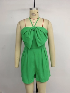 Detail of green romper featuring a large bow decoration and halter neck tie