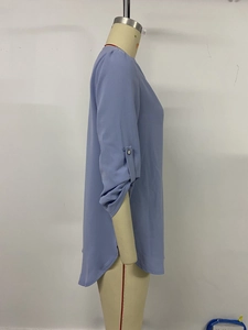 Detail view of light blue chiffon shirt featuring adjustable sleeves and curved hemline