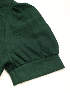 Detailed close-up of dark green puff sleeves with textured twill fabric on shirt dress