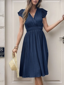 Detail of navy blue pleated dress with V-neckline and high waist pleated skirt texture
