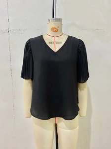 Detail of a black V-neck chiffon shirt featuring pleated puff sleeves on a display mannequin
