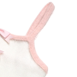 Dettaglio del top bianco a costine con bordo in pelliccia sintetica rosa e fiocco