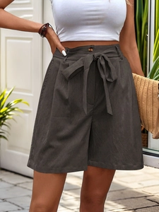 Detail of high-waisted dark grey casual shorts with waist tie and textured fabric