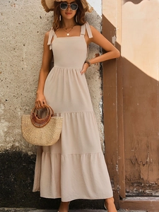 Elegant beige tiered maxi dress with bow shoulder straps for summer vacation style