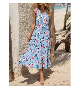 Detail of light blue sleeveless dress with pink floral print and layered skirt on beach
