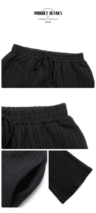 Detail of high waist drawstring and pleated texture on these black wide leg casual pants