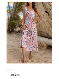 Detail of floral summer dress with V-neck, buttons, and drawstring waist on beach