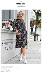 Détail de l'imprimé floral sur une robe noire à manches longues avec ceinture à la taille