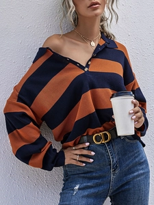 Detail of navy and orange striped knit sweater with golden button polo collar