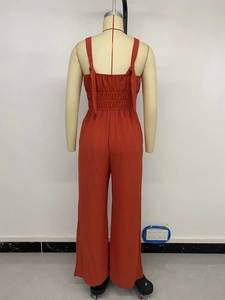 Detail of rust orange jumpsuit featuring thin straps and backless elastic waist design