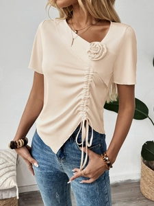 Dettaglio della rosa 3D e della coulisse sulla maglia in maglina beige con scollo a V