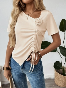 Dettaglio di un top beige a costine con rosa 3D e coulisse laterale regolabile