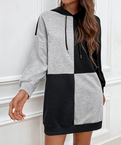 Detail of knitted patchwork hooded dress featuring black and grey blocks and ribbed cuffs