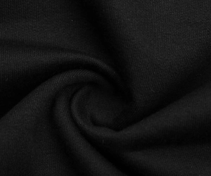 Detailed macro view of the soft black knitted fabric texture on hooded dress
