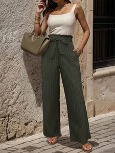Dettaglio dei pantaloni a gamba larga verde oliva a vita alta con eleganti pieghe