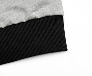 Detail of light grey heather fabric stitched with black rib knit hem and neat seams