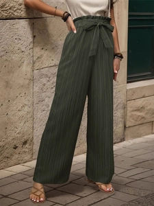 Dettaglio dei pantaloni a vita alta con trama plissettata e cintura a fiocco elegante