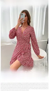 Detail view of red floral wrap dress featuring V-neckline and ruffled hemline accents