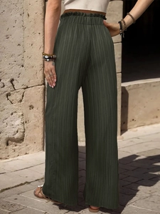 Dettaglio dei pantaloni a gamba larga a vita alta verde oliva con trama plissettata