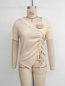 Dettaglio del top in maglia beige con scollo a V irregolare, volant e rosa fatta a mano