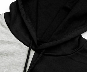 Close-up of contrast color knit hoodie showing the gray fabric texture and black drawstrings