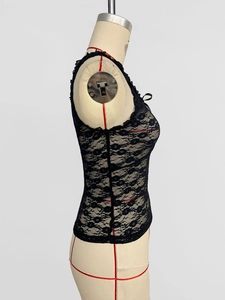 Detail of black floral lace tank top featuring a delicate ribbon bow on the neckline