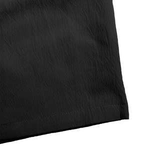 Close-up of black summer shorts featuring crinkle texture fabric and fine flat-lock stitching