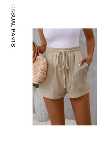 Detail of high waisted casual shorts featuring elastic drawstring waist and ribbed texture