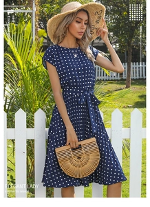 Detail of navy blue polka dot summer dress showing waist tie and pleated A-line skirt