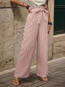 Dettaglio dei pantaloni plissé rosa a gamba larga con vita alta e fiocco regolabile