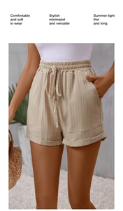 Detail view of khaki high-waisted shorts with drawstring elastic waist and side pockets